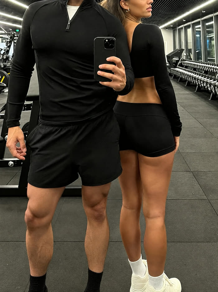 Couple in matching black sets taking a gym mirror selfie